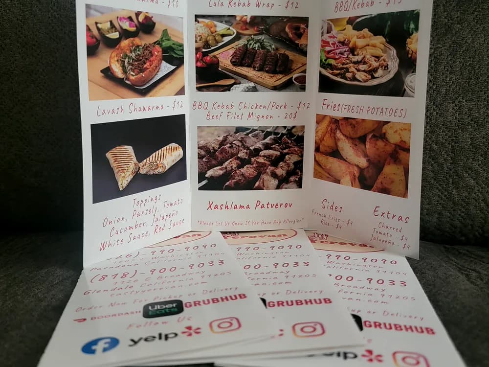 Open tri-fold catering menu with full-colour food photography
