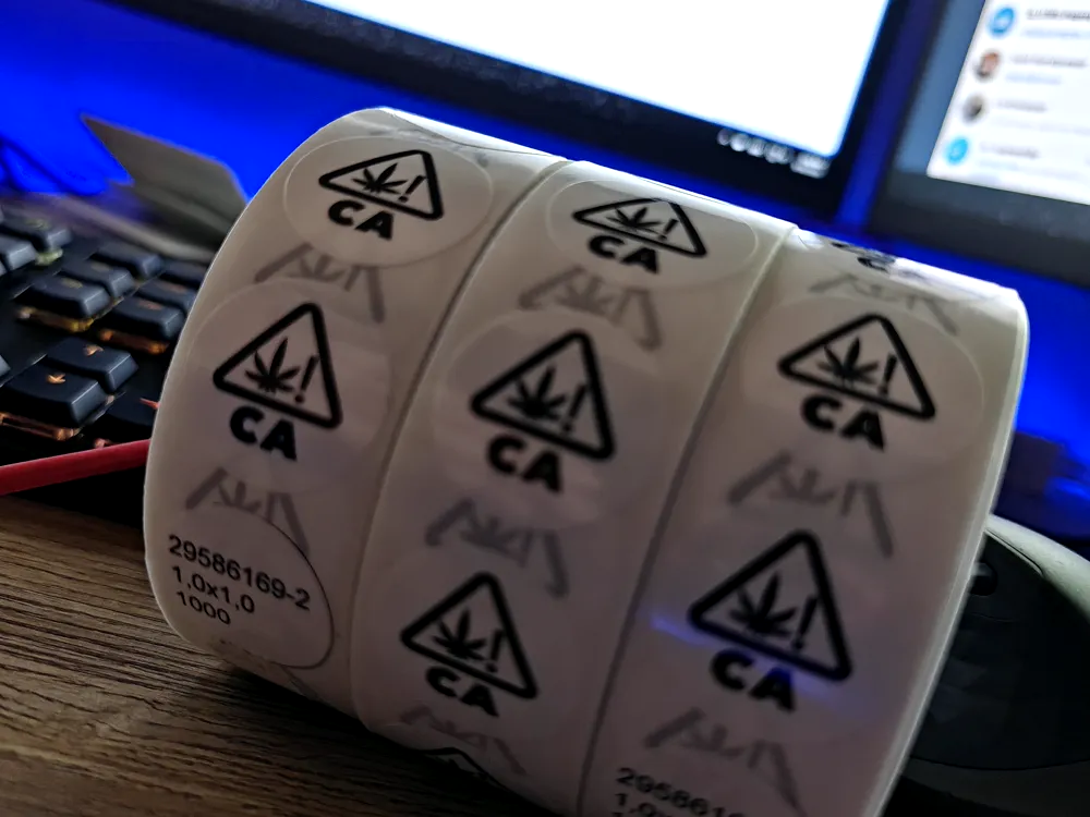 Roll of California regulatory compliance labels with warning symbols