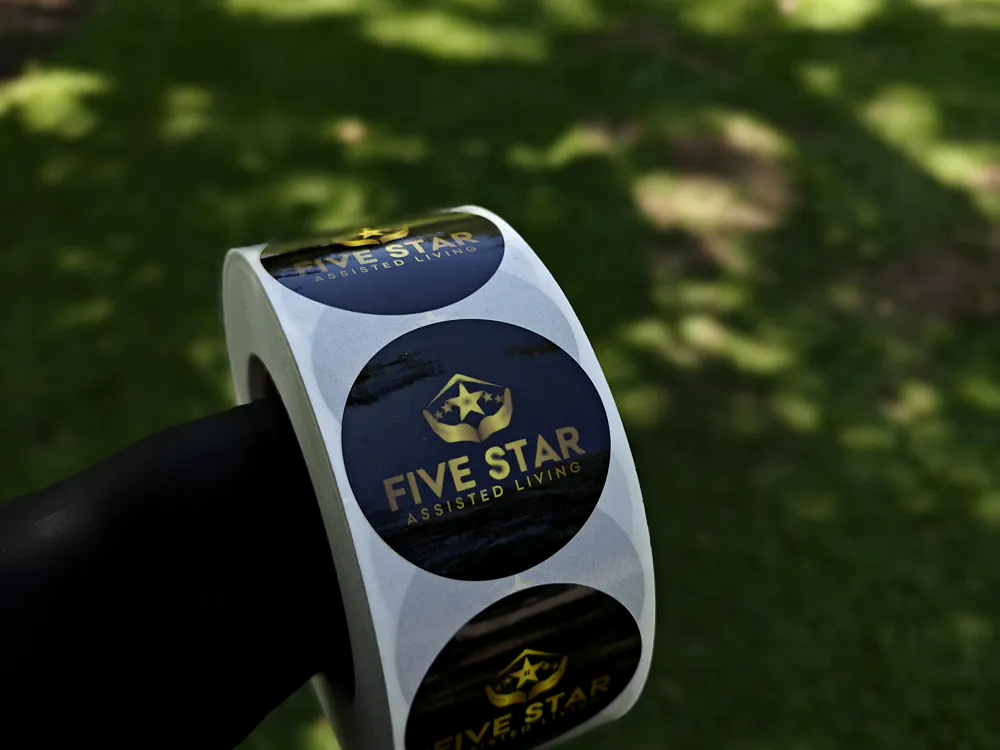 Roll of circular gold foil labels with a navy and gold star logo