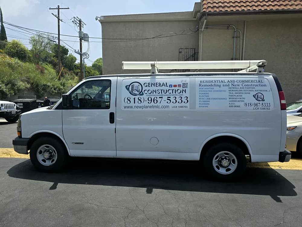 Side panel of a work van showing printed service listings and contact details