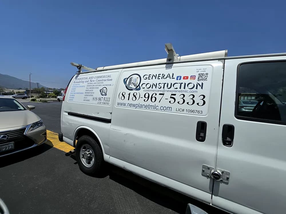 White work van with printed graphics, licence details and phone number