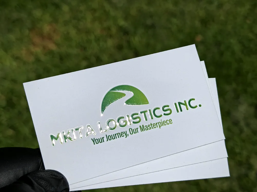A neat stack of white MKITA Logistics business cards held in a gloved hand