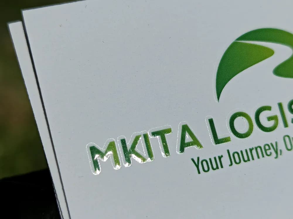 Thick white business card with a raised gloss green logo for MKITA Logistics