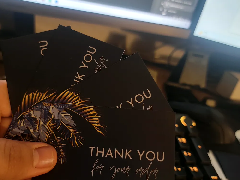 Black thank-you card with gold foil botanical illustration