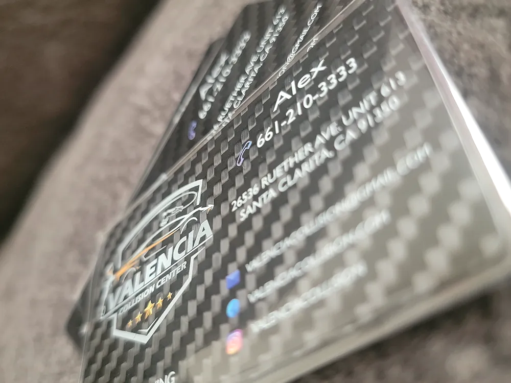 Business cards with a raised carbon-fibre texture and silver foil detail