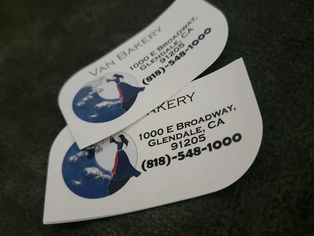 Business cards die-cut to a curved wave shape for Van Bakery on East Broadway