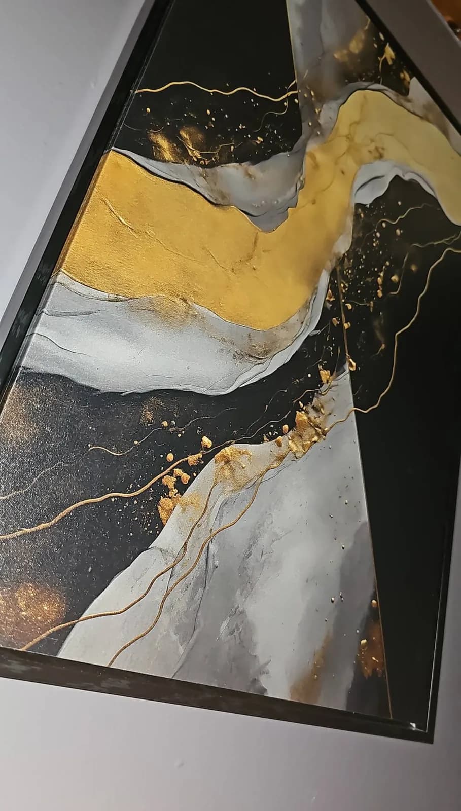 A framed black and gold abstract canvas we printed