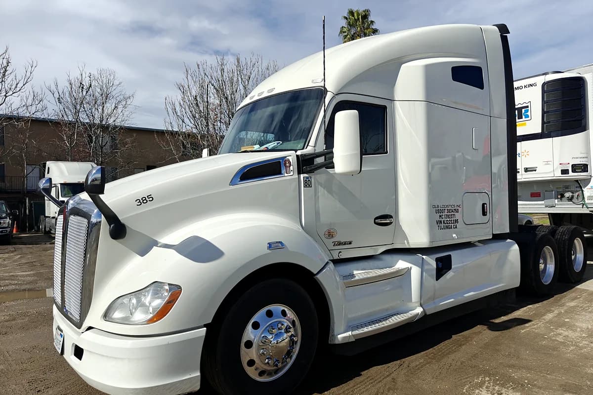 Kenworth semi tractor with cab door lettering and regulatory numbers applied