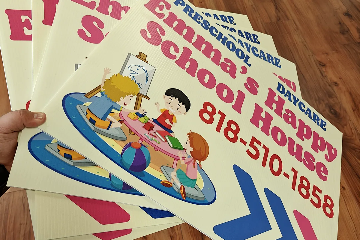 Stack of printed directional daycare signs for Chef Emma’s Happy School House