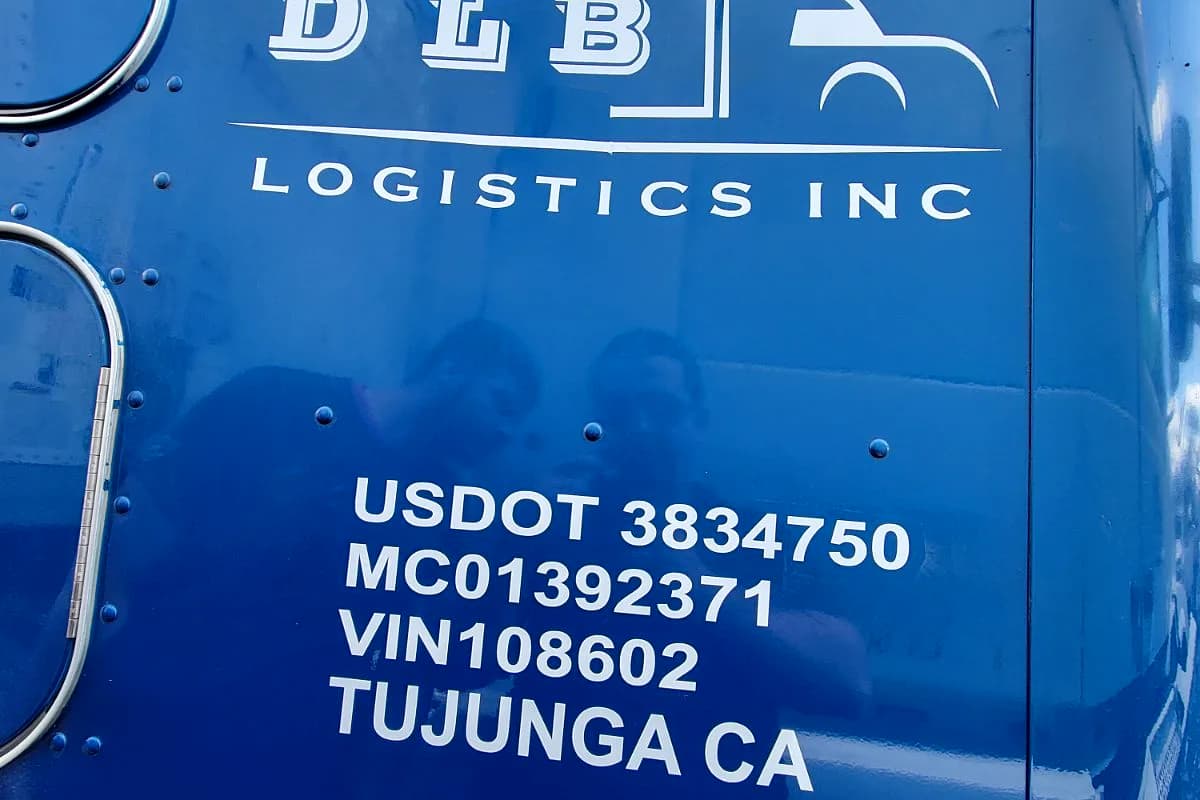 Cut-vinyl USDOT and MC number decals applied to a blue box truck for DLB Logistics of Tujunga