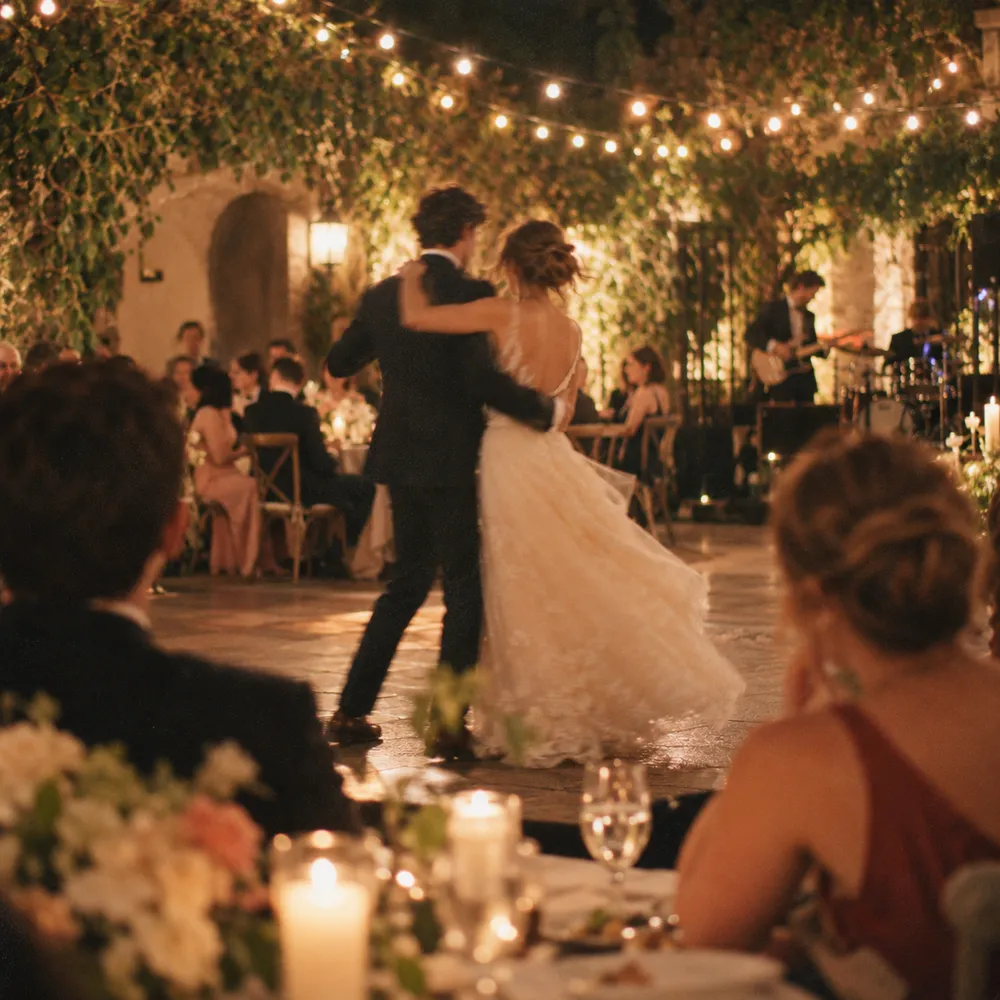 A couple sharing a first dance under string lights